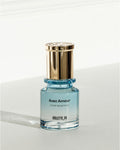 Avec Amour (Huile de parfum) VIOLETTE_FR on a small clear glass bottle with light blue liquid and a gold cap.