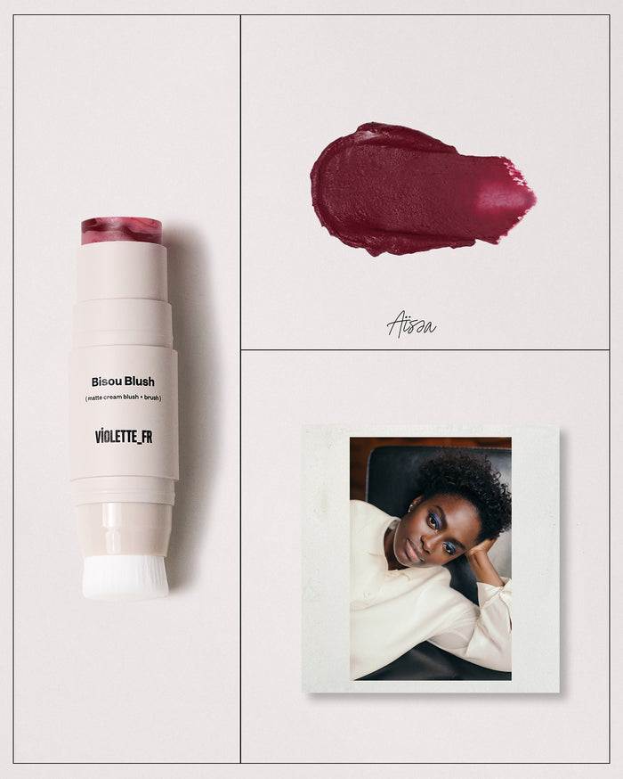 Bisou Blush (matte cream blush + brush) by VIOLETTE_FR, a beige stick with swirled pink and red cream blush and a brush, shown with a dark berry red swatch named Aïssa, and a portrait of a woman with deep skin tone wearing blue eyeshadow.