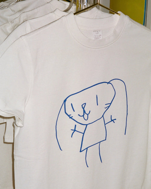 White t-shirt with a blue childlike drawing of a bunny-like figure. The collar tag reads: 'XX SMALL This T-shirt is made with responsibly sourced fabric and is organic.'