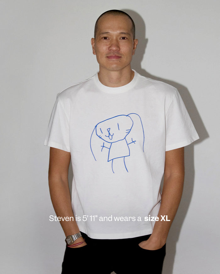 Steven is 5'11" and wears a size XL. He is a man with medium skin tone wearing a white t-shirt featuring a blue line drawing of a bunny.