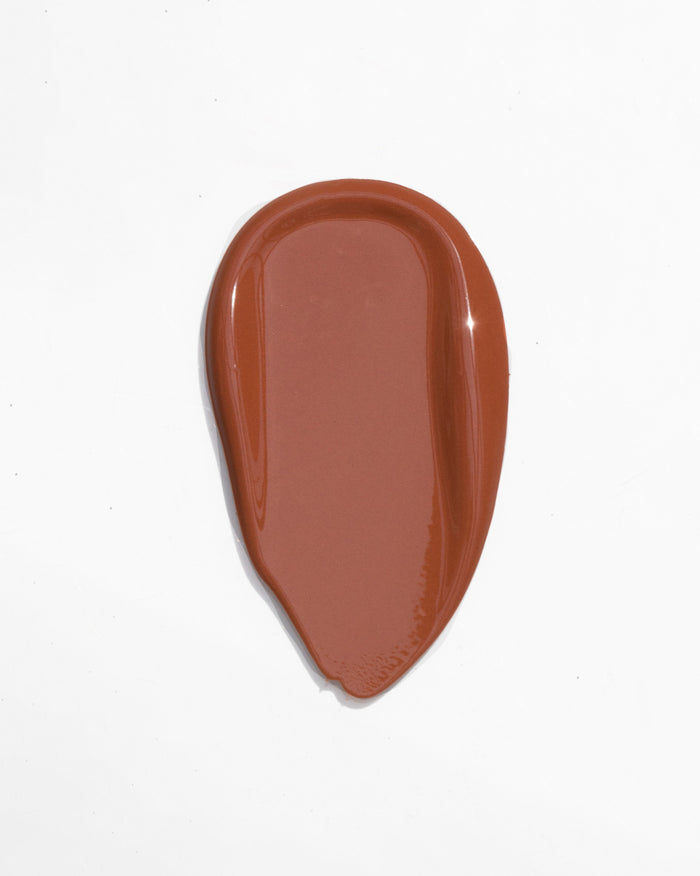 Glossy reddish-brown liquid swatch in a teardrop shape.
