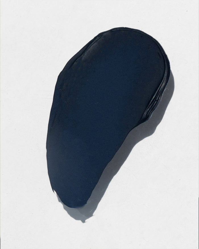 A swatch of dark navy blue, almost black, creamy product.