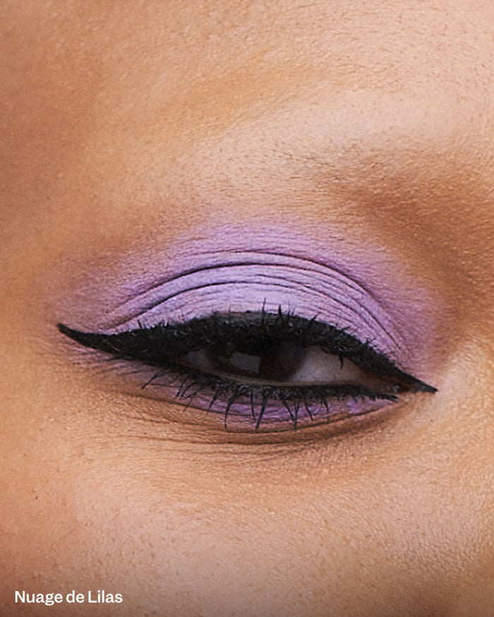 Nuage de Lilas: Close-up of a medium skin tone eye with vibrant purple eyeshadow and black winged eyeliner.