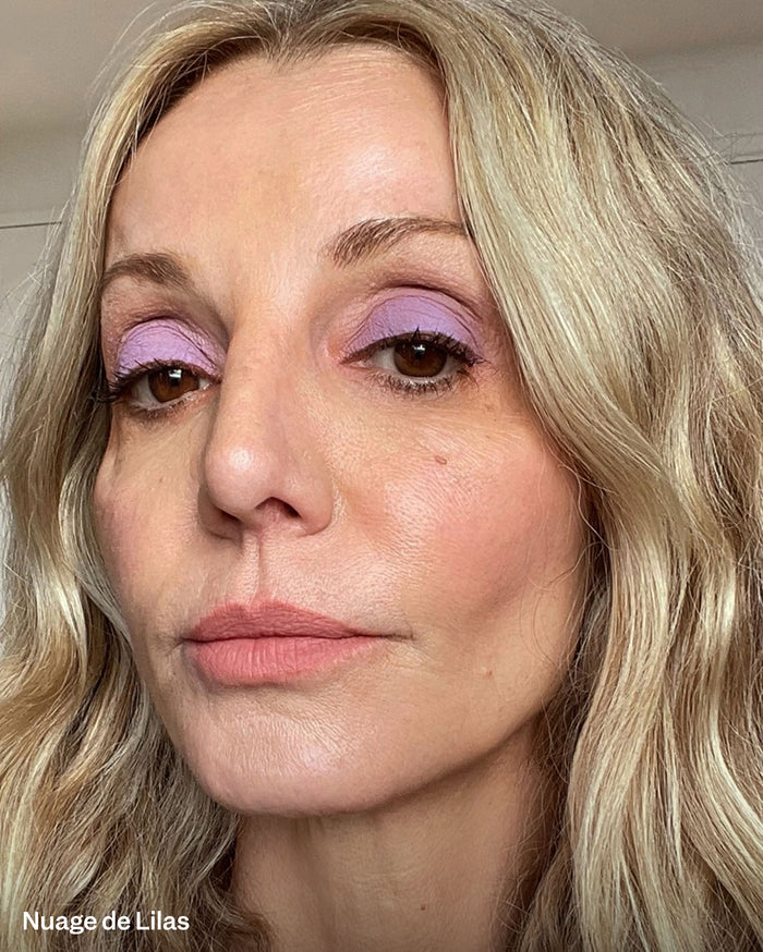 Nuage de Lilas. Close-up of a woman with light skin tone, blonde hair, wearing purple eyeshadow and soft pink lipstick.